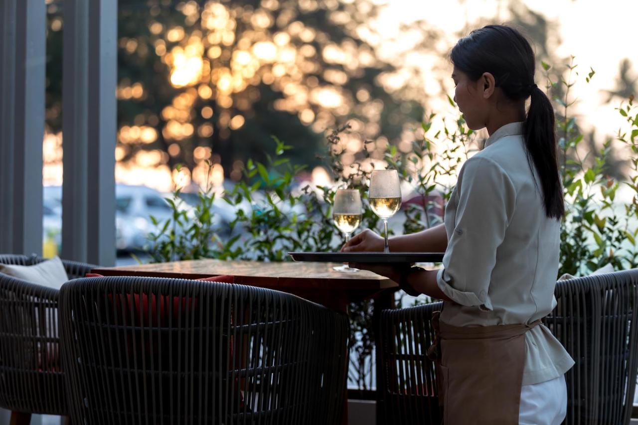 Outrigger Surin Beach Resort - Sha Extra Plus Exteriér fotografie A waitress clearing a table